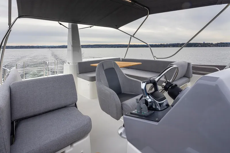 Slide: The Image of 2026 Beneteau Swift Trawler 41 Flybridge with modern seating and steering, cruising on open water. - 22