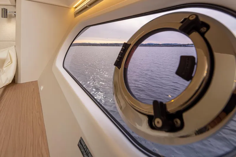Slide: The Image of Porthole view from 2026 Beneteau Swift Trawler 41 Fly, overlooking serene waters at sunset. - 29