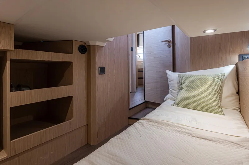 Slide: The Image of 2026 Beneteau Swift Trawler 41 Fly cabin interior with bed and wooden shelves. - 32