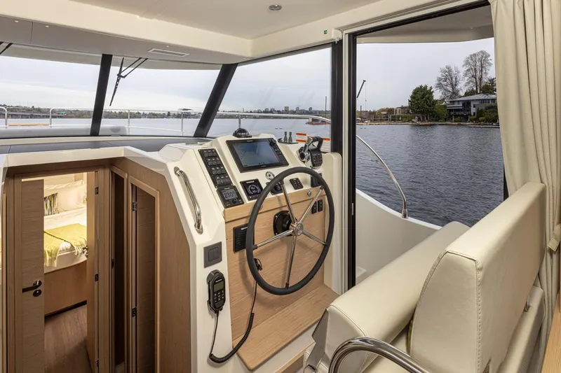 Slide: The Image of 2026 Beneteau Swift Trawler 41 Fly interior with helm, cabin, and water view. - 6
