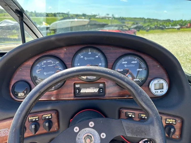 Slide: The Image of Dashboard of a 1999 Malibu 20 Response LX boat with gauges and controls. - 14