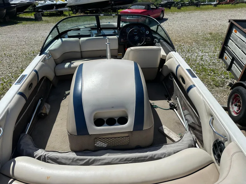 Slide: The Image of 1999 Malibu 20 Response LX boat interior with seating and steering wheel, parked outdoors. - 9