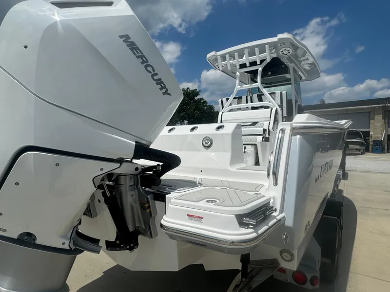 Slide: The Image of 2025 Blackfin 302 CC boat with Mercury engine, docked under a clear blue sky. - 12