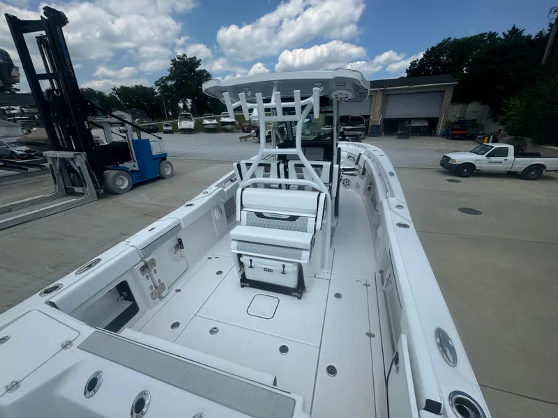 Slide: The Image of 2025 Blackfin 302 CC boat with spacious deck and seating, docked at a marina. - 14