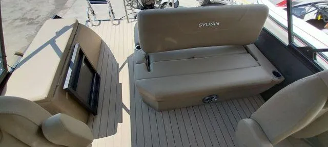 Slide: The Image of 2024 Sylvan Mirage 8520 CLZ DH boat interior with beige seating and flooring. - 11
