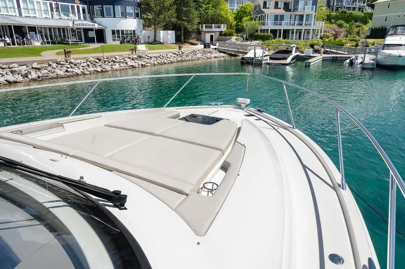 Slide: The Image of 2022 Tiara Yachts C49 Coupe docked in a scenic marina setting. - 11