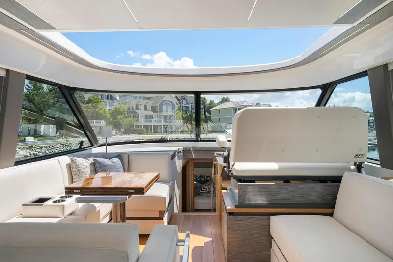Slide: The Image of Interior of 2022 Tiara Yachts C49 Coupe, featuring luxurious seating and panoramic windows. - 22