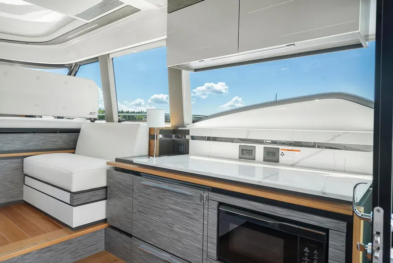 Slide: The Image of Luxurious interior of 2022 Tiara Yachts C49 Coupe with modern seating and kitchen amenities. - 25