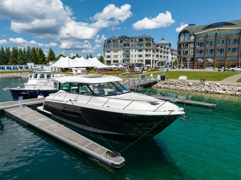 Slide: The Image of 2022 Tiara Yachts C49 Coupe docked in a scenic marina with buildings in the background. - 3