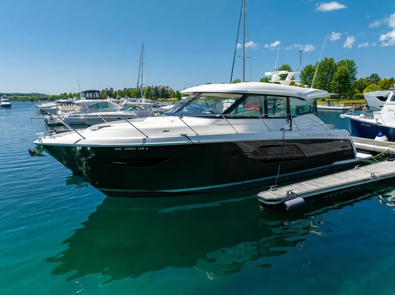Slide: The Image of 2022 Tiara Yachts C49 Coupe docked in a serene marina setting. - 6