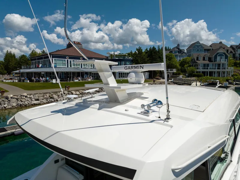 Slide: The Image of 2022 Tiara Yachts C49 Coupe docked near waterfront homes and a clubhouse. - 7