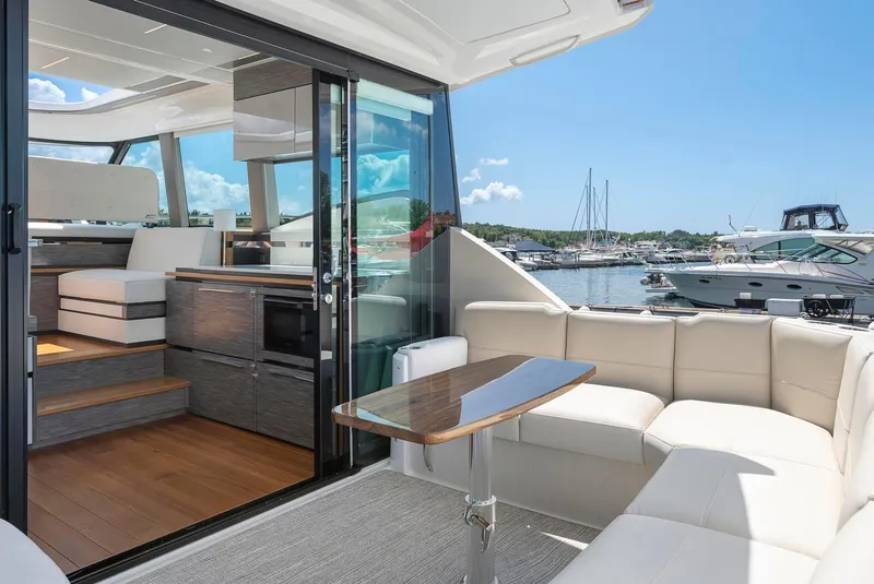 Slide: The Image of 2022 Tiara Yachts C49 Coupe interior with luxurious seating and marina view. - 9