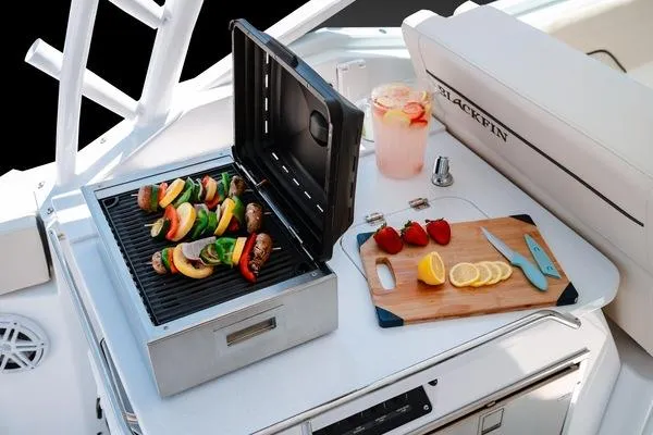 Slide: The Image of Blackfin 302 DC 2025 boat with grill, cutting board, and lemonade pitcher. - 9