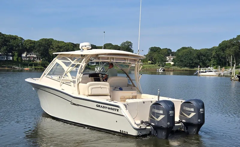 The Image of 2017 Grady-White Freedom 335 boat with twin Yamaha engines on a calm lake. - 0