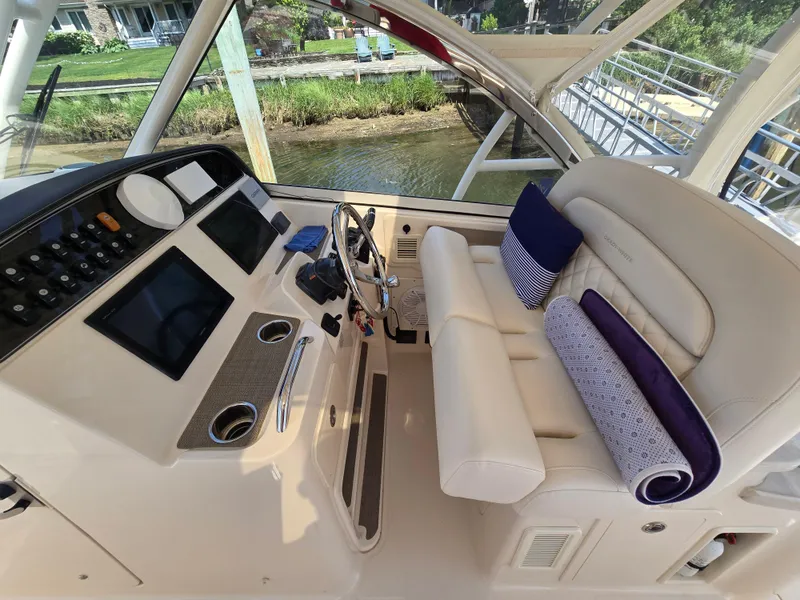 Slide: The Image of 2017 Grady-White Freedom 335 boat interior with helm, steering wheel, and cushioned seating. - 13
