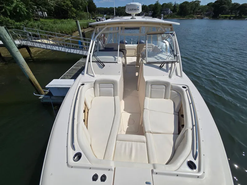 Slide: The Image of 2017 Grady-White Freedom 335 boat docked, featuring spacious seating and Garmin equipment. - 17