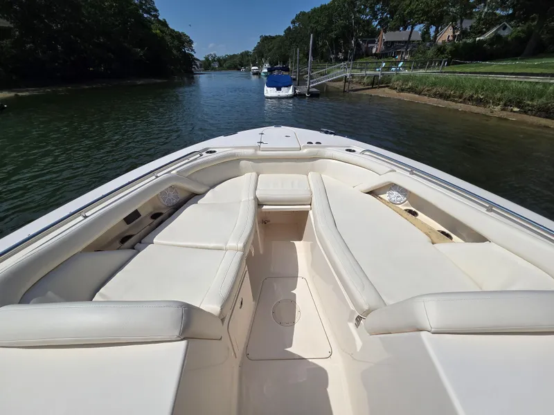 Slide: The Image of 2017 Grady-White Freedom 335 boat interior with spacious seating on a calm waterway. - 18