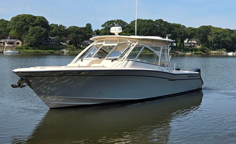 Slide: The Image of 2017 Grady-White Freedom 335 boat on a calm lake with lush green shoreline. - 2