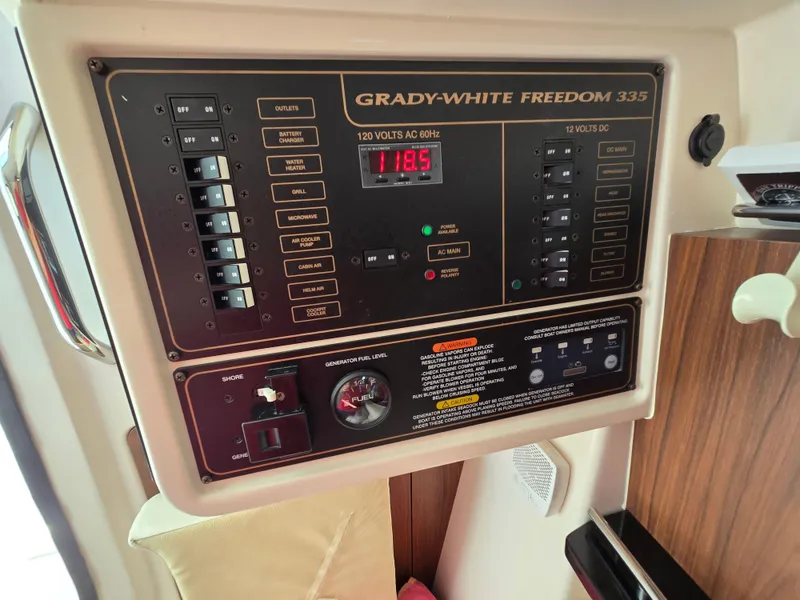 Slide: The Image of Control panel of 2017 Grady-White Freedom 335 boat, showing electrical switches and fuel gauge. - 21