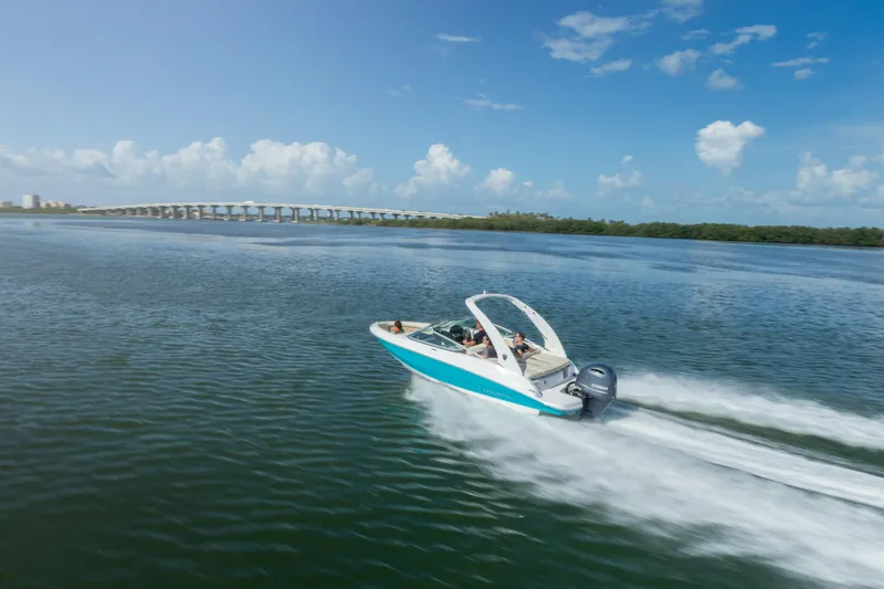 Slide: The Image of 2026 Regal 21 OBX speedboat cruising on a sunny day, with a scenic bridge in the background. - 8