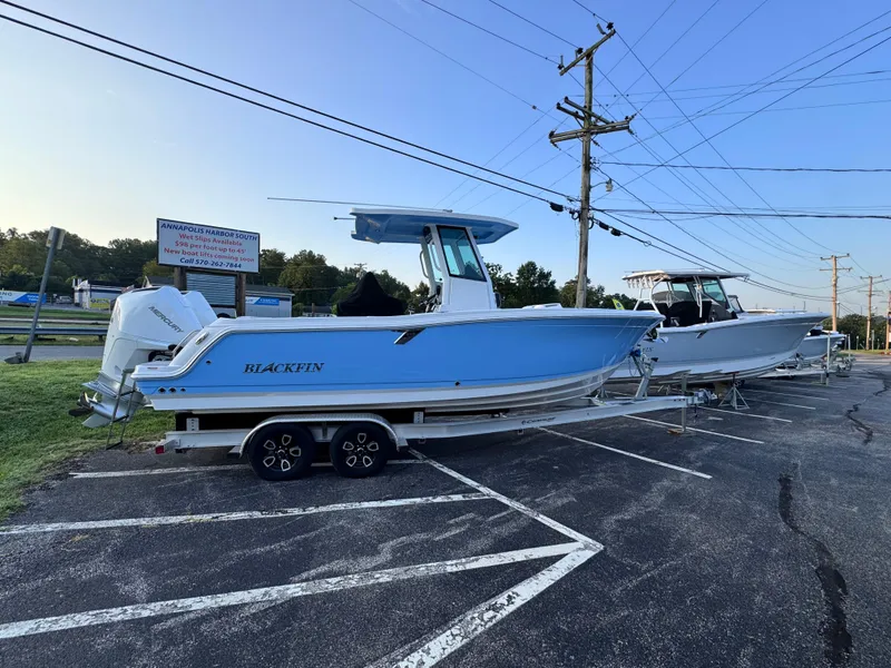 Slide: The Image of 2025 Blackfin 252 CC boat on trailer in parking lot, clear sky background. - 1