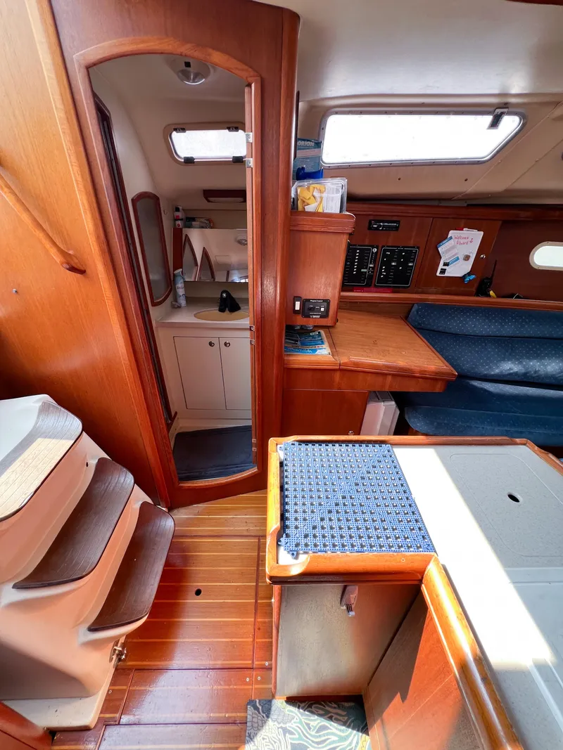 Slide: The Image of Interior of a 2002 Hunter 356 sailboat, featuring wood finishes and compact design. - 17