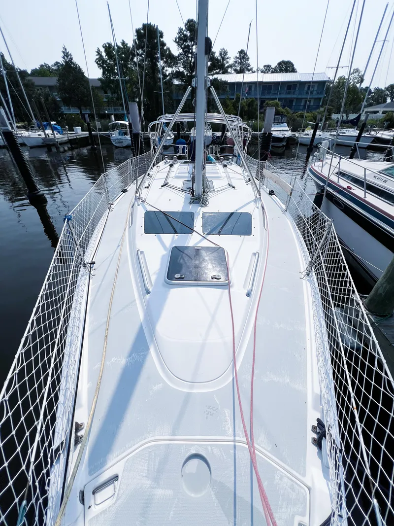 Slide: The Image of 2002 Hunter 356 sailboat docked at marina, top deck view with rigging and netting. - 2