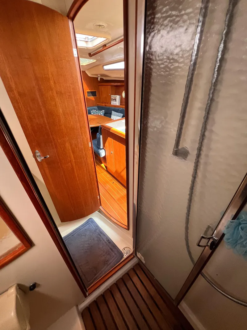 Slide: The Image of Interior of 2002 Hunter 356 sailboat showing shower and cabin area with wooden finishes. - 22