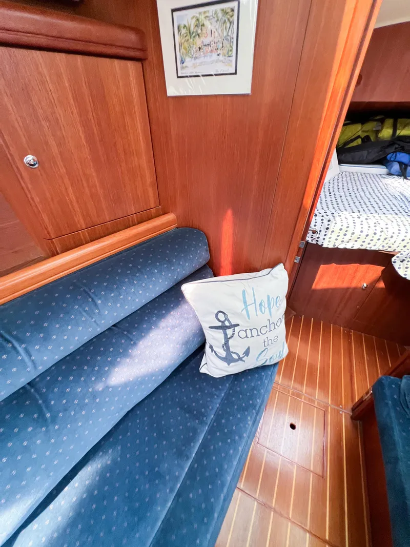 Slide: The Image of Interior of 2002 Hunter 356 sailboat with blue seating and decorative pillow. - 26