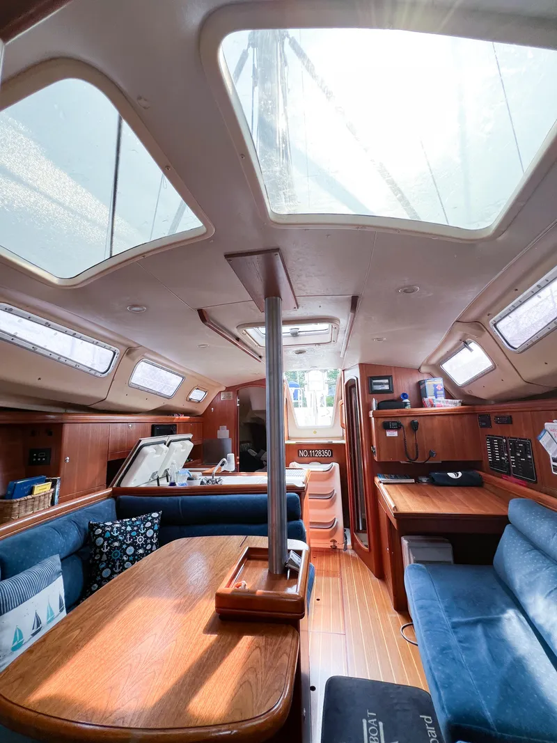 Slide: The Image of Interior of a 2002 Hunter 356 sailboat with wooden furnishings and blue seating. - 31