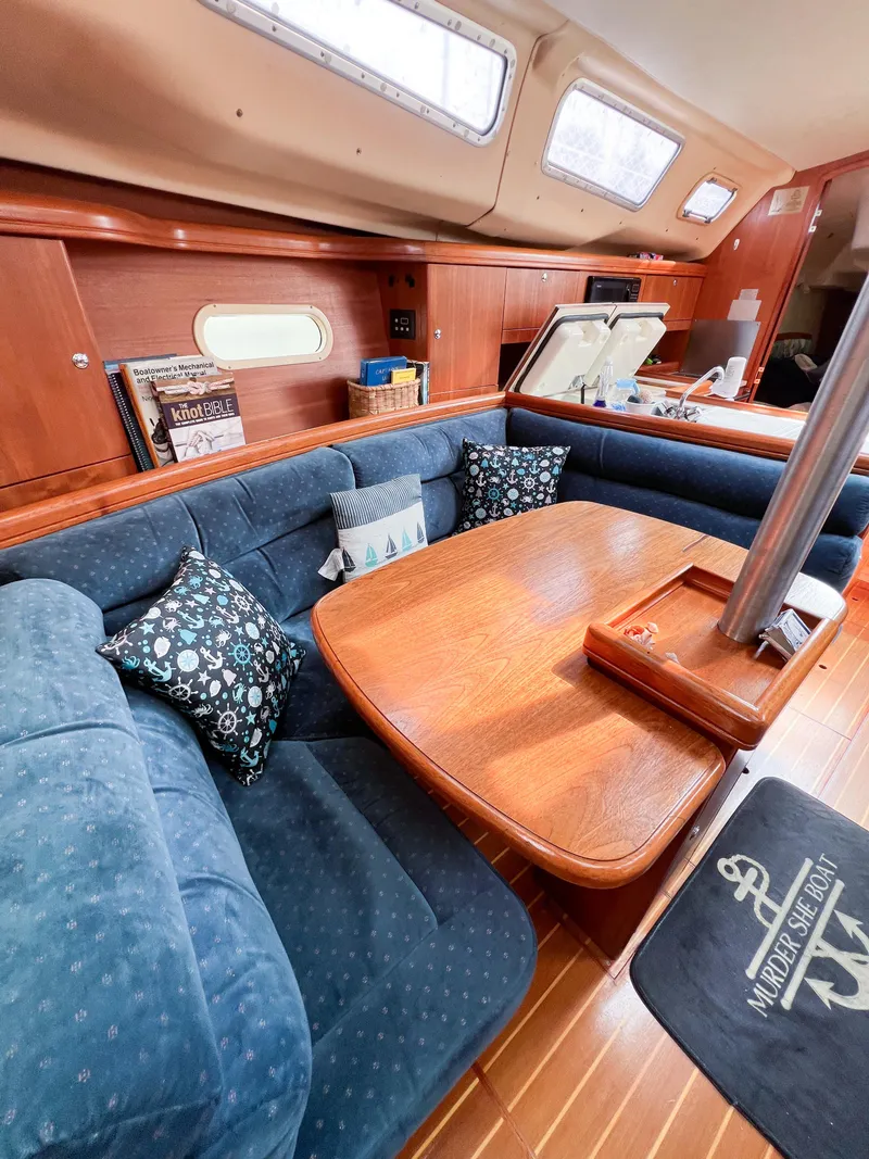 Slide: The Image of Cozy interior of 2002 Hunter 356 sailboat with blue seating and wooden table. - 37