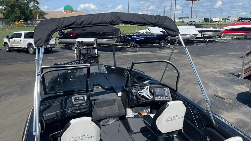 Slide: The Image of 2025 Skeeter Solera 205 boat interior with steering wheel and dashboard, parked in a marina. - 8