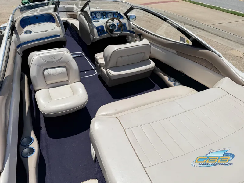 Slide: The Image of Interior of a 1998 Regal 2100 LSR boat with white seating and blue accents. - 11