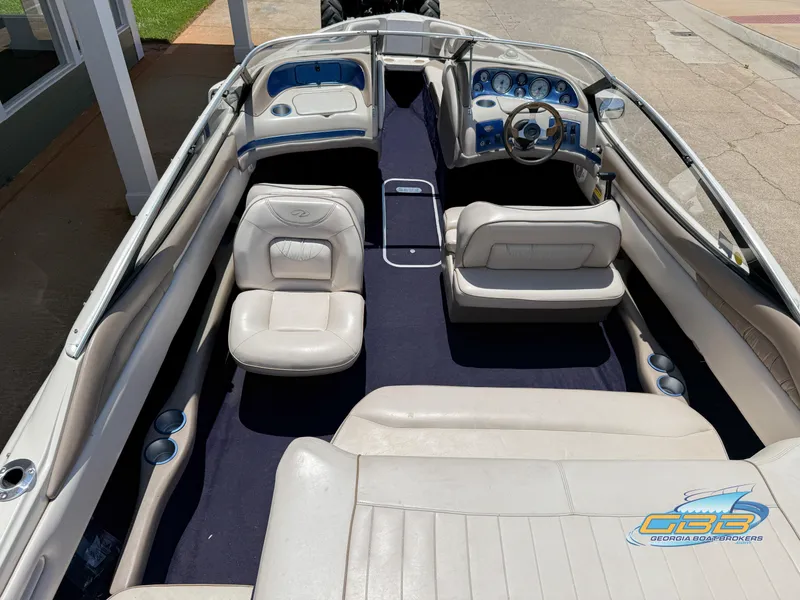Slide: The Image of 1998 Regal 2100 LSR boat interior with white seating and blue dashboard. - 12