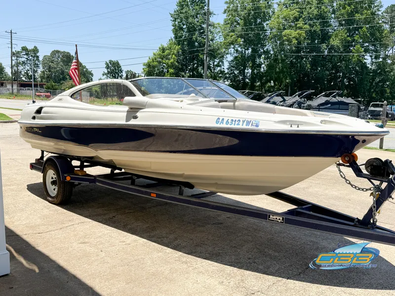 Slide: The Image of 1998 Regal 2100 LSR boat on trailer, parked outdoors with trees in background. - 4