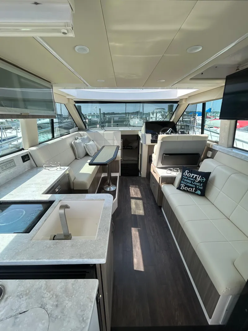 Slide: The Image of 2020 Regal 38 Grande Coupe interior with modern seating, kitchenette, and helm. - 12