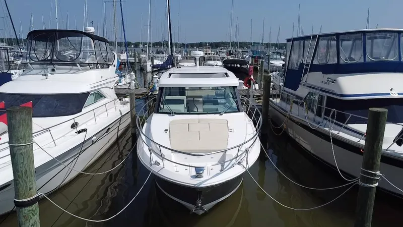 Slide: The Image of 2020 Regal 38 Grande Coupe docked between two boats in a marina. - 3