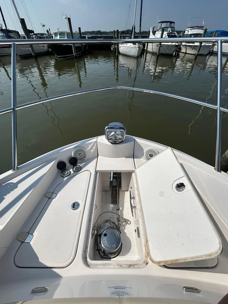 Slide: The Image of Bow view of 2020 Regal 38 Grande Coupe at marina, showcasing anchor and deck details. - 6