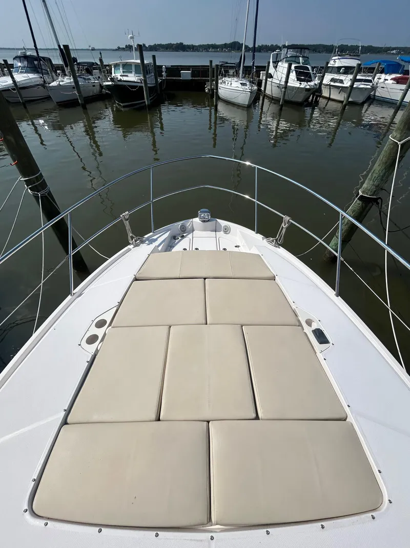 Slide: The Image of 2020 Regal 38 Grande Coupe yacht with sunpad, docked at marina with other boats. - 7