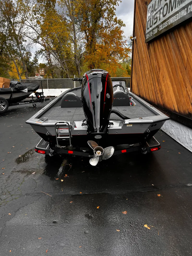 Slide: The Image of 2024 Vexus AVX1880 boat with outboard motor, parked on wet pavement. - 7