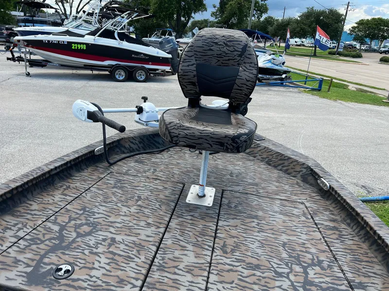 Slide: The Image of 2022 Xpress H190B boat with camo pattern seat and deck, parked near other boats. - 12