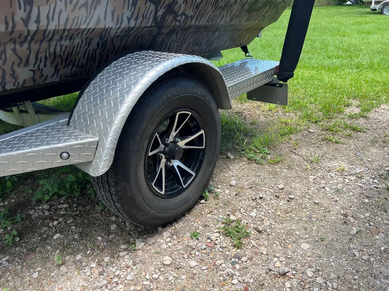 Slide: The Image of Trailer wheel of 2022 Xpress H190B boat on gravel and grass. - 14