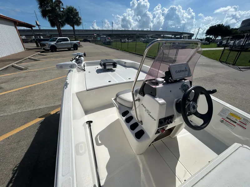 Slide: The Image of 2020 Mako Pro Skiff 17 CC boat with Garmin navigation, parked outdoors under a sunny sky. - 10