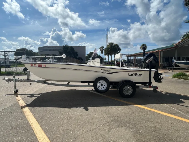Slide: The Image of 2020 Mako Pro Skiff 17 CC boat on trailer under a partly cloudy sky. - 4