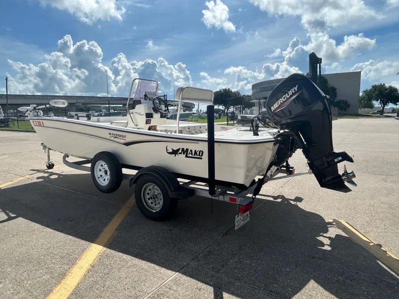 Slide: The Image of 2020 Mako Pro Skiff 17 CC boat on trailer, parked under a sunny sky. - 5