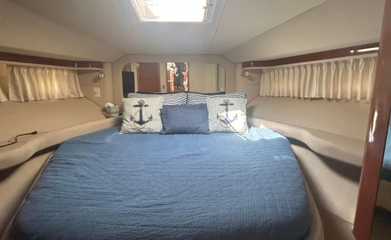 Slide: The Image of Luxurious 2002 Sea Ray 480 Motor Yacht bedroom with nautical-themed decor. - 18