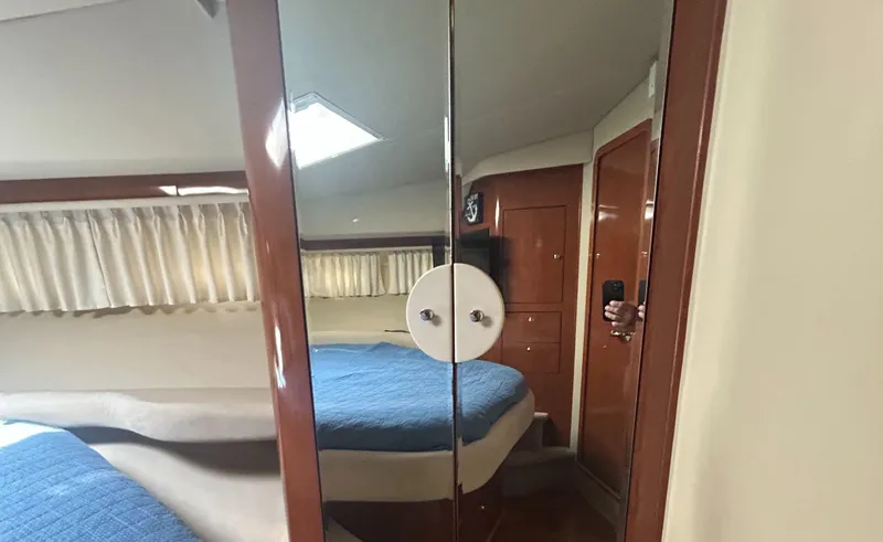 Slide: The Image of Interior of 2002 Sea Ray 480 Motor Yacht with mirrored closet and blue bedding. - 19