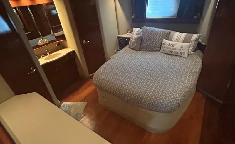 Slide: The Image of Cozy bedroom in 2002 Sea Ray 480 Motor Yacht with nautical-themed decor and wooden flooring. - 22