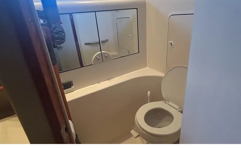 Slide: The Image of Bathroom interior of 2002 Sea Ray 480 Motor Yacht with toilet and mirrored cabinet. - 25