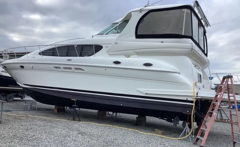 Slide: The Image of 2002 Sea Ray 480 Motor Yacht on dry dock, side view with overcast sky. - 34